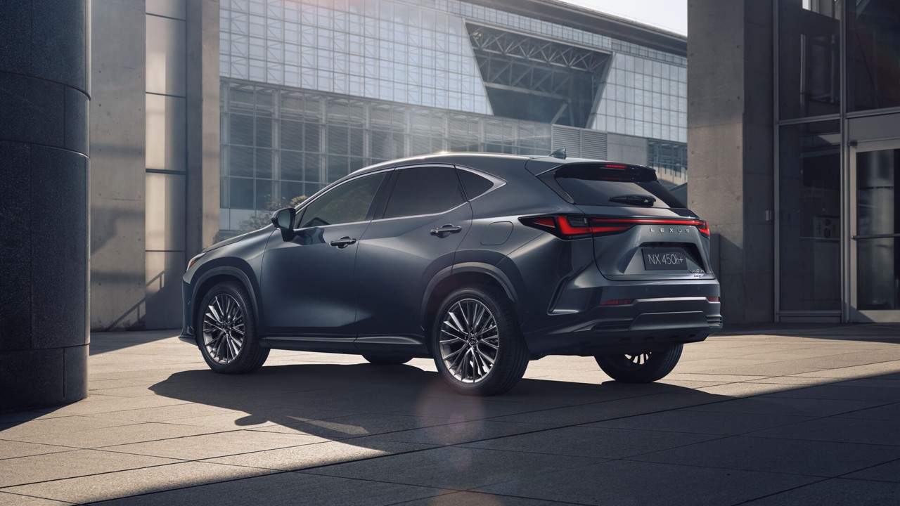 A parked Lexus NX 450h+ infront of glass structure 