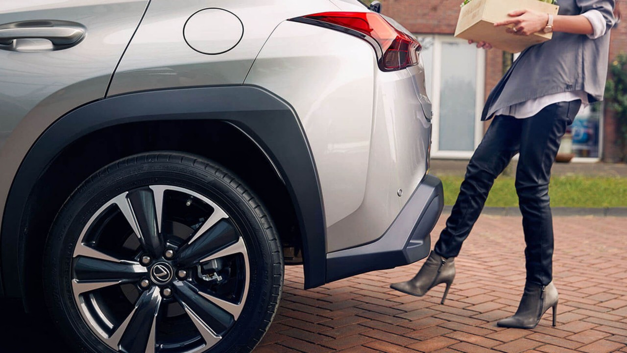 A woman using the hands-free powered tailgate on the Lexus UX 300e