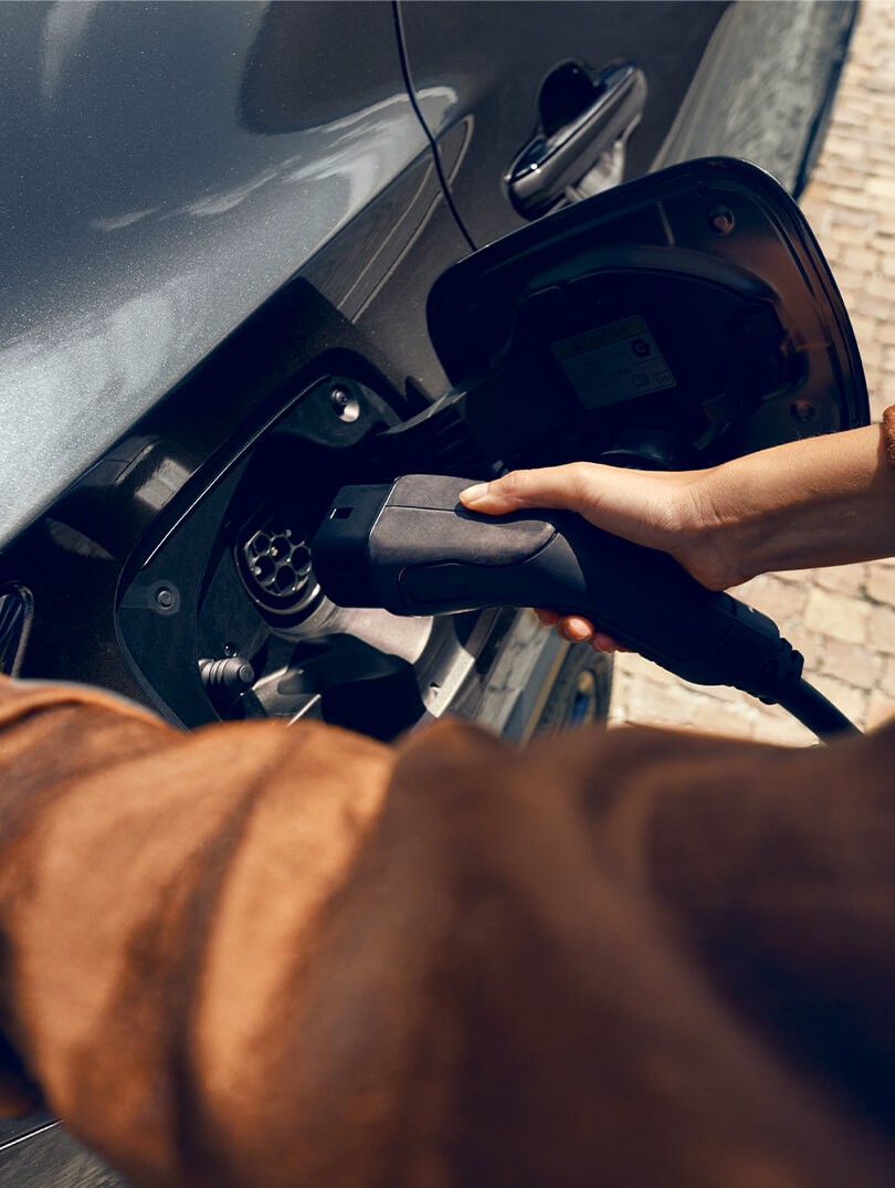 A man plugging in a charger to a Lexus NX